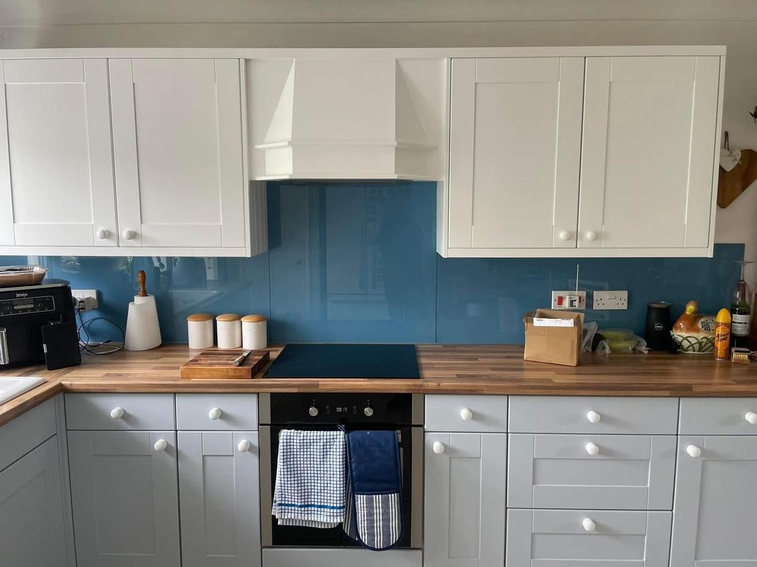 White shaker kitchen with walnut worktop and blue splashback